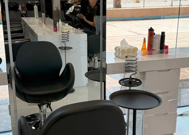 Modern salon setup at L'Art de Coiffure Salon in Dubai, Dubai, AE, featuring stylish chairs and hair products.