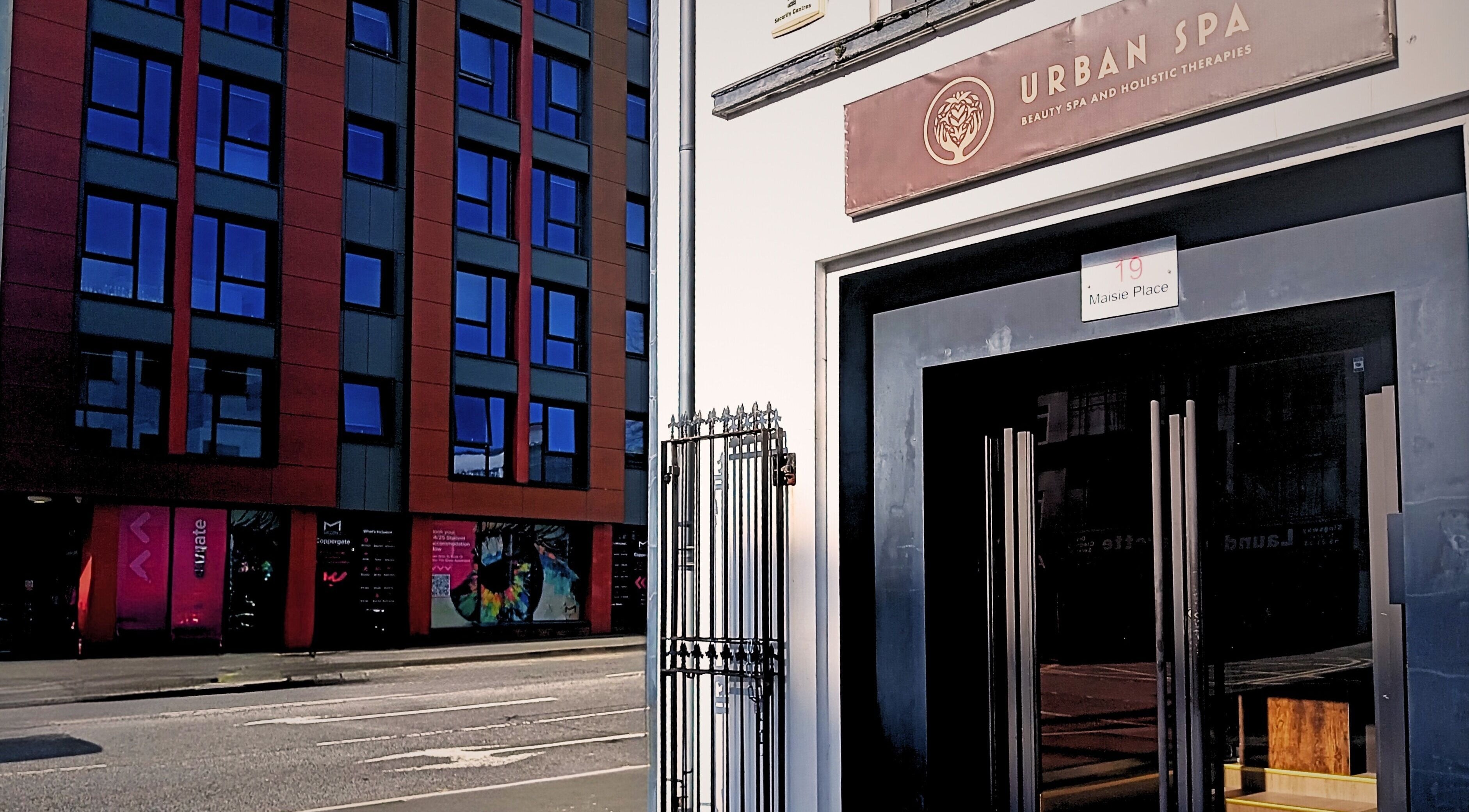 Entrance of Essential Bodywork by Sara Colautti at Swansea, Wales, GB opposite modern blue glass building.