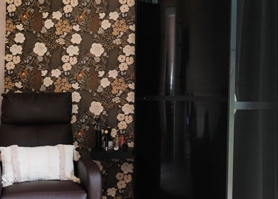 Relaxing chair at Smile and Glo, Oxford Station, Ontario, CA with floral wallpaper and cozy pillow.