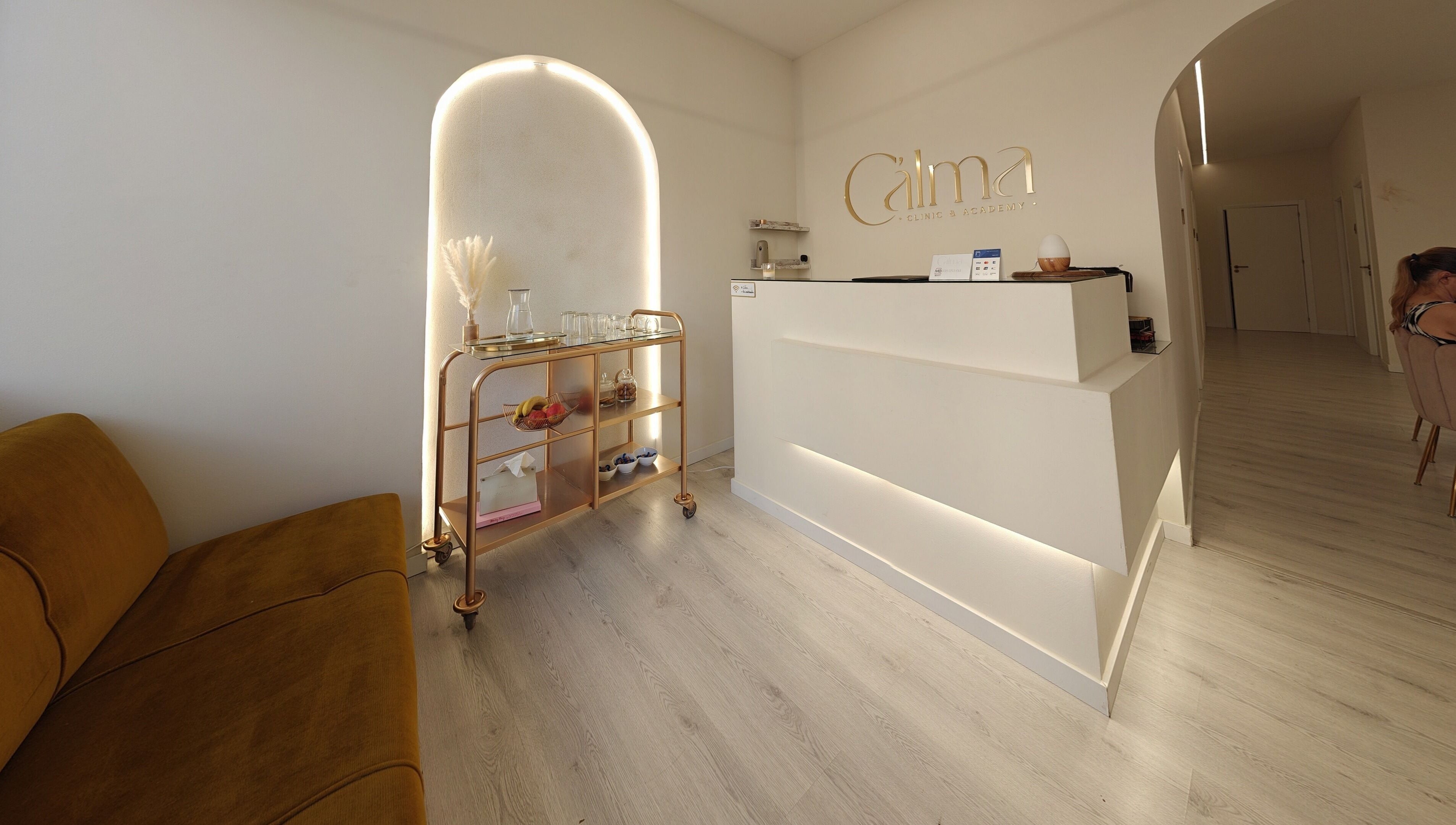 Recepção da C'alma Clinic & Academy, Montijo, Setúbal, PT com sofá e carrinho decorado.
