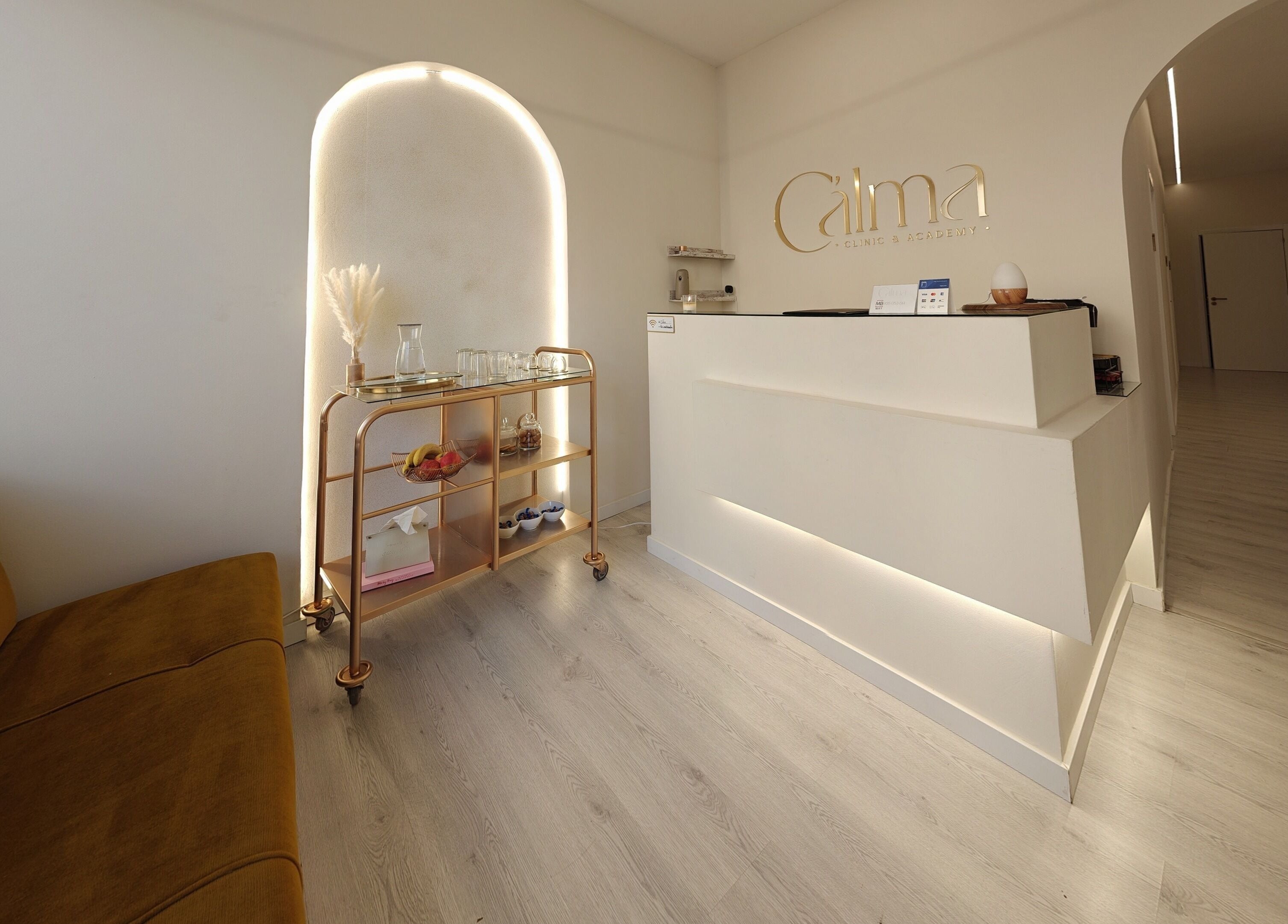 Recepção da C'alma Clinic & Academy, Montijo, Setúbal, PT com sofá e carrinho decorado.
