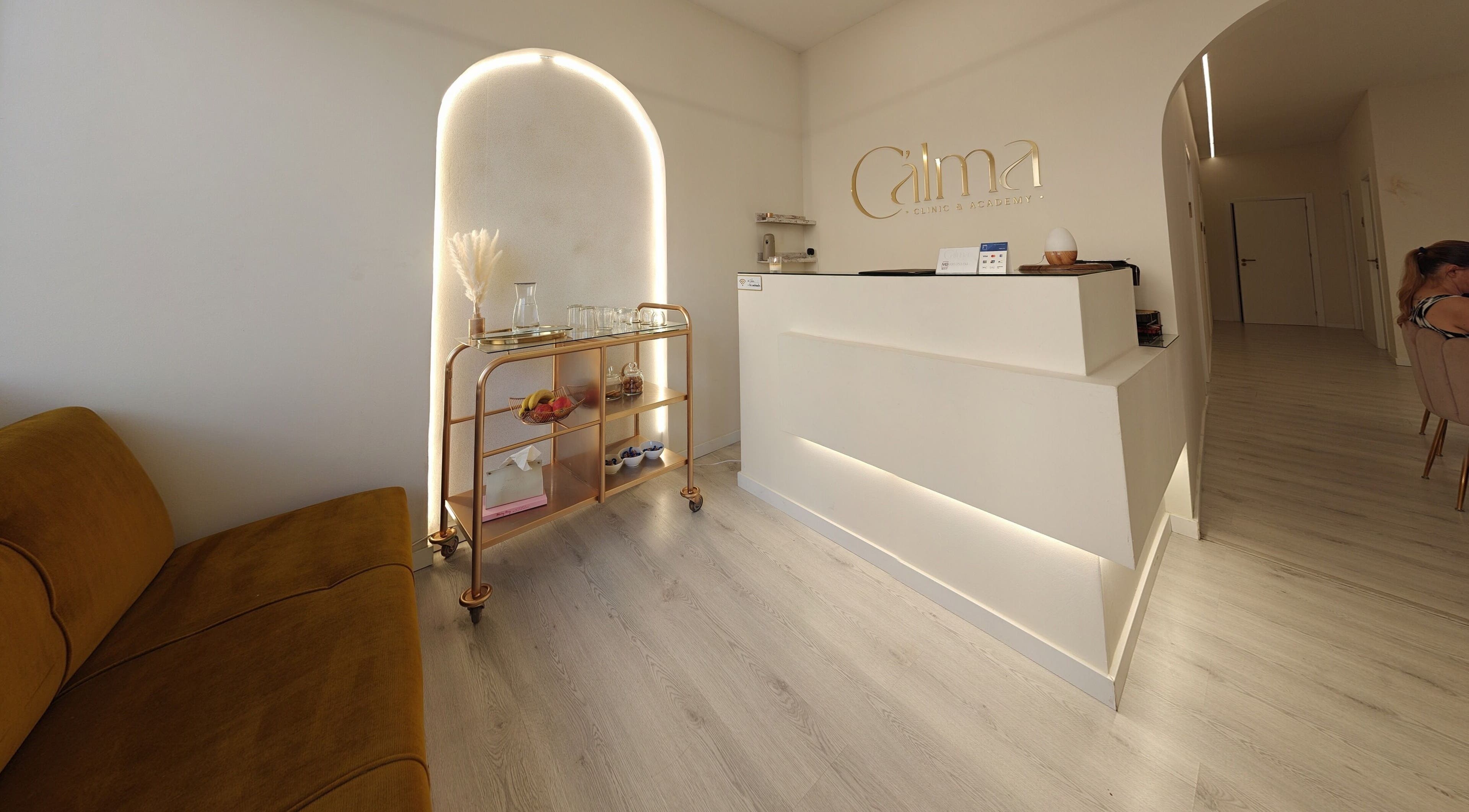 Recepção da C'alma Clinic & Academy, Montijo, Setúbal, PT com sofá e carrinho decorado.
