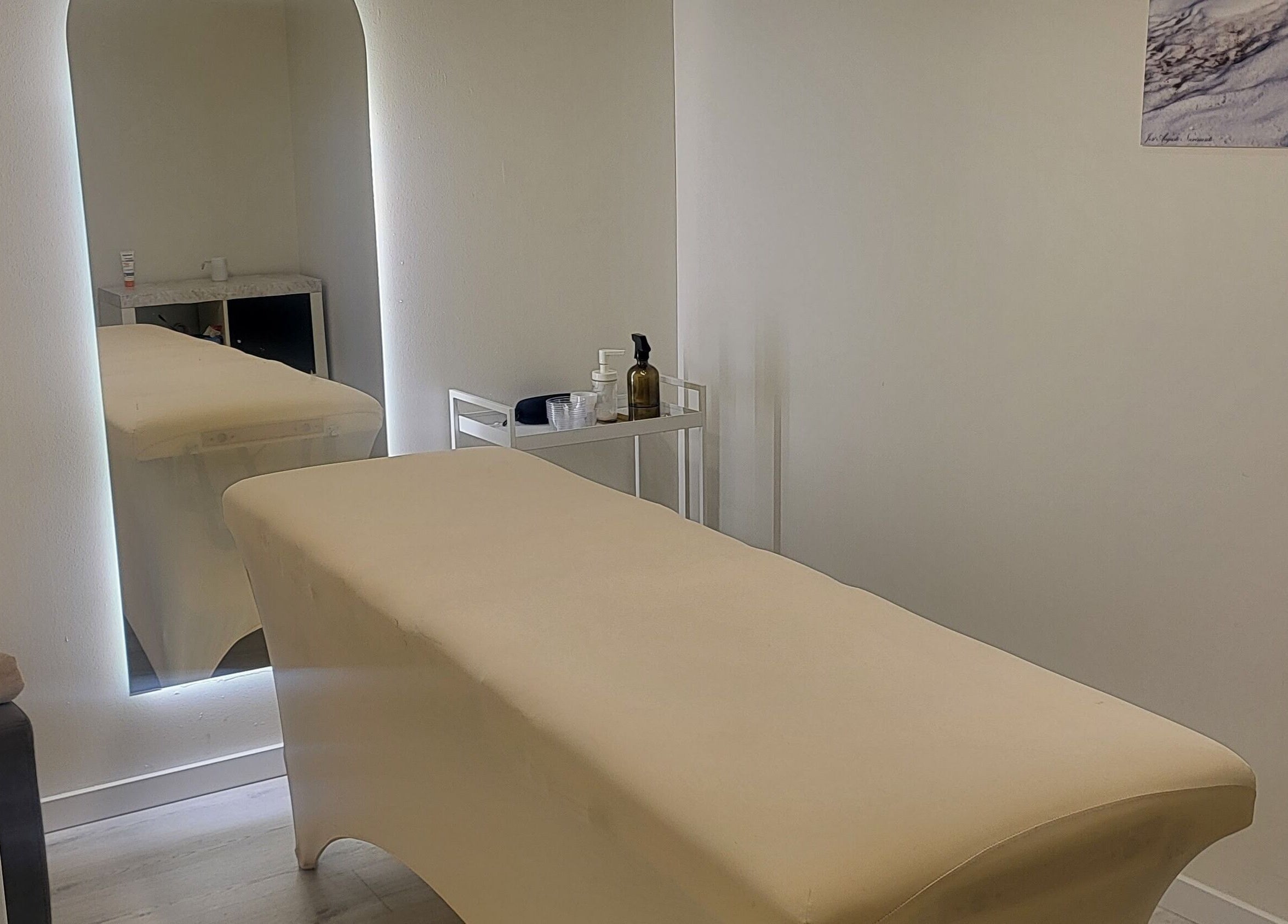 Sala de massagem em C'alma Clinic & Academy, Montijo, Setúbal, PT, com mesa e espelho moderno.