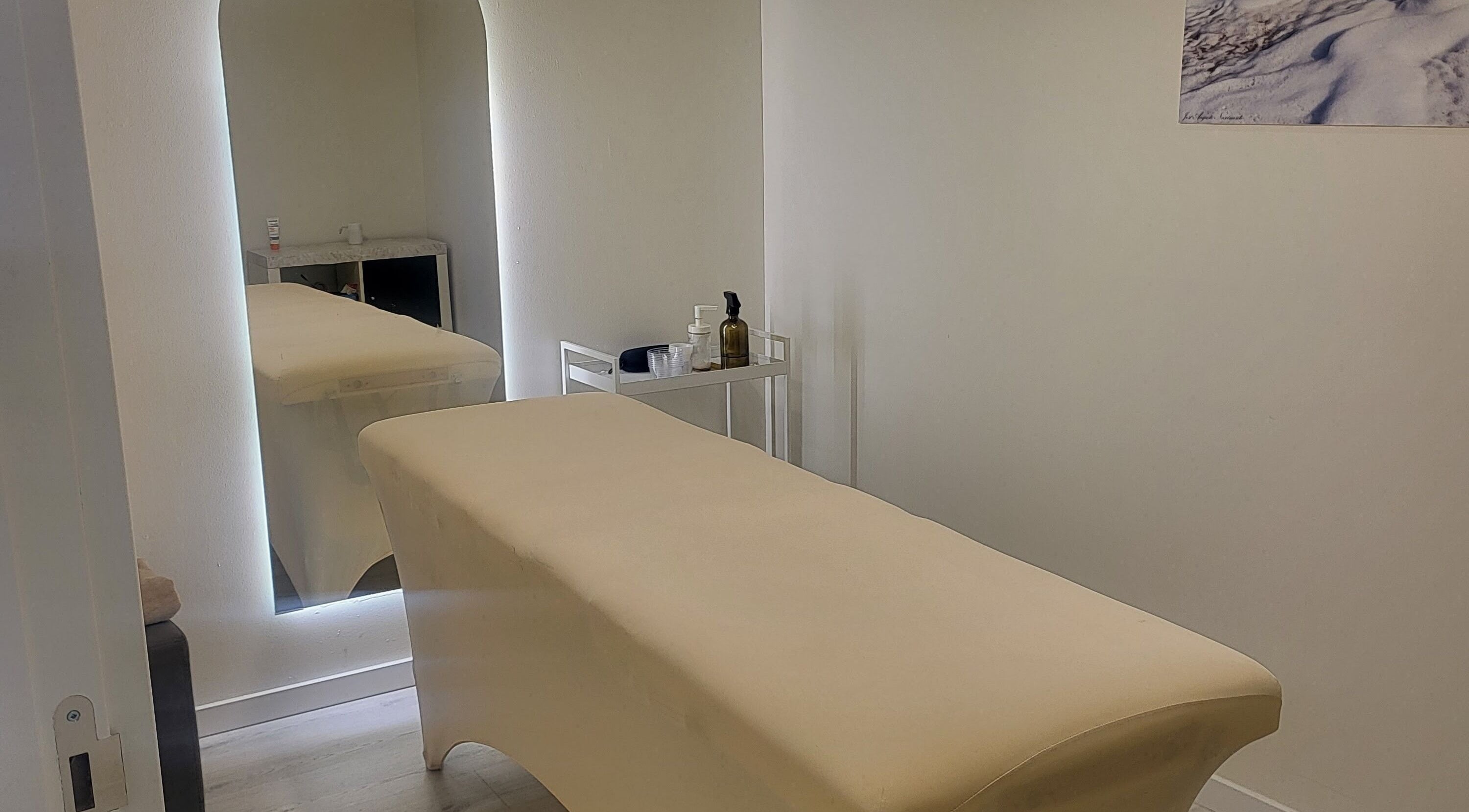 Sala de massagem em C'alma Clinic & Academy, Montijo, Setúbal, PT, com mesa e espelho moderno.