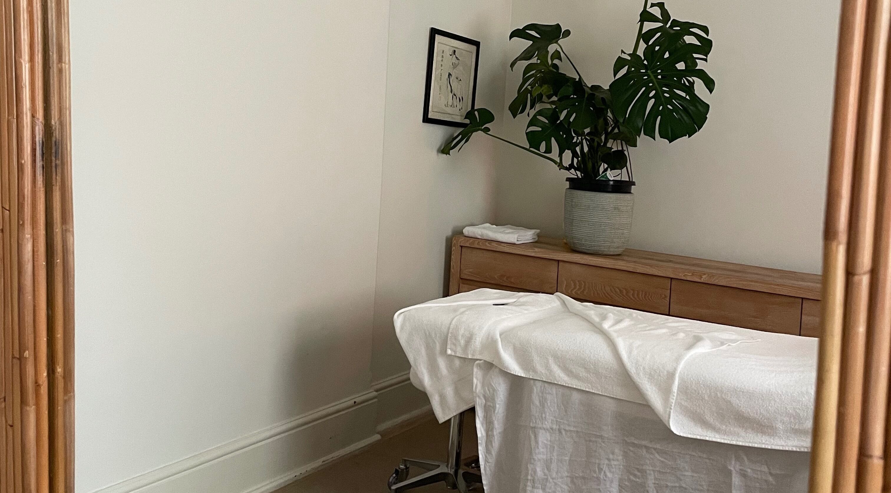 Calm massage room at Restoree | Holistic Remedial Massage, Bondi, New South Wales, AU with plants and wooden decor.