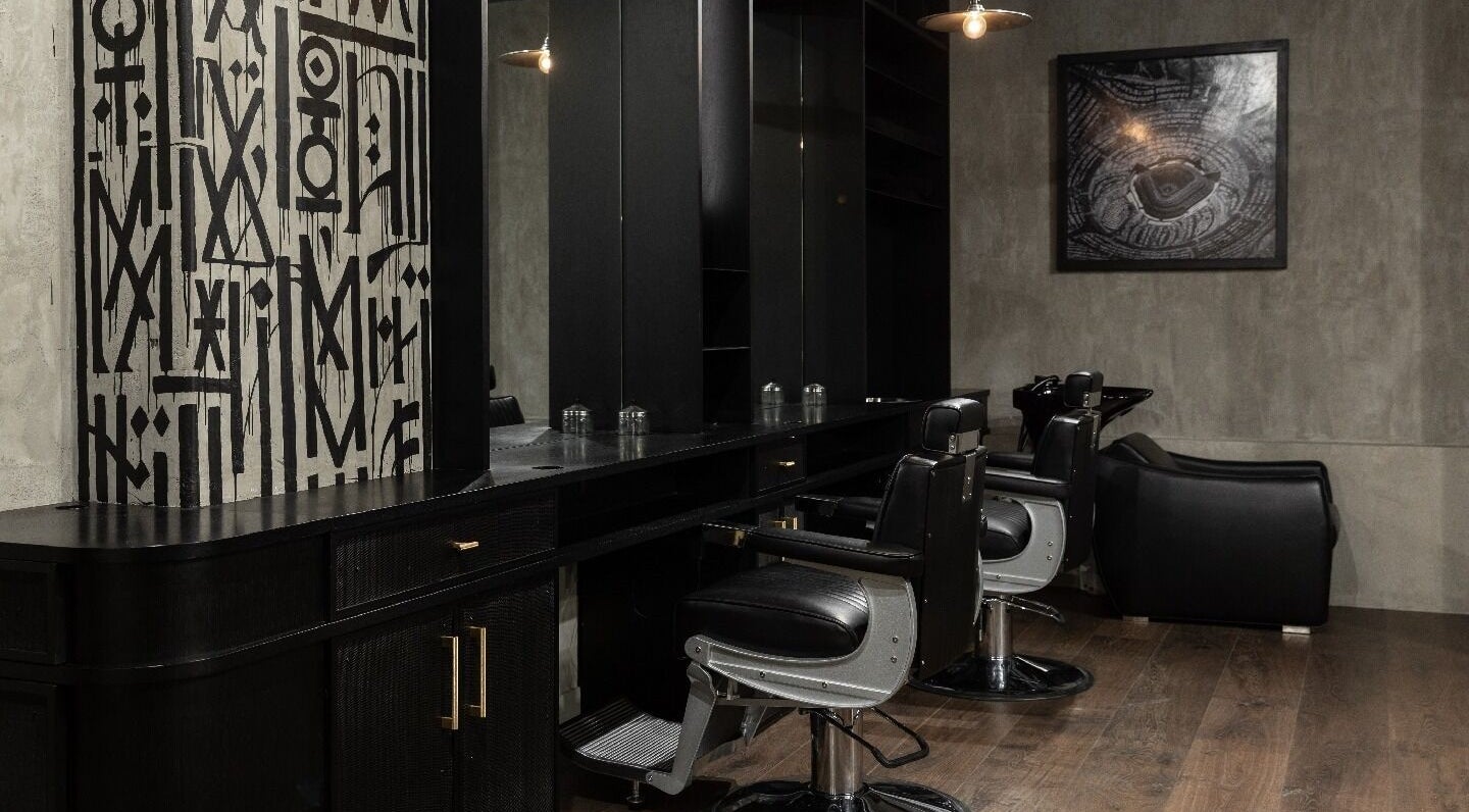 Modern salon interior at The Gentry - Commercial Bay, Auckland, NZ, featuring sleek black chairs and decor.