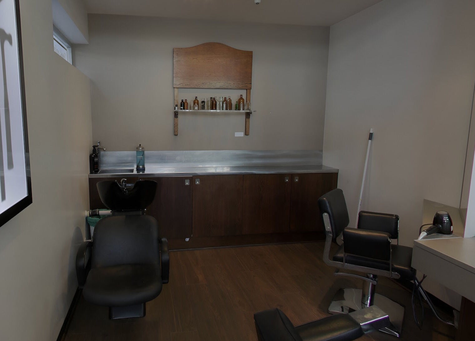 Elegant salon at The Gentry - Shortland Street, Auckland, Auckland, NZ with chic black styling chairs and wood accents.