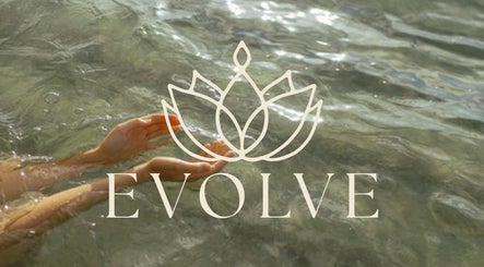Hands in a tranquil sea with Evolve Avalon logo at Avalon Beach, New South Wales, AU.