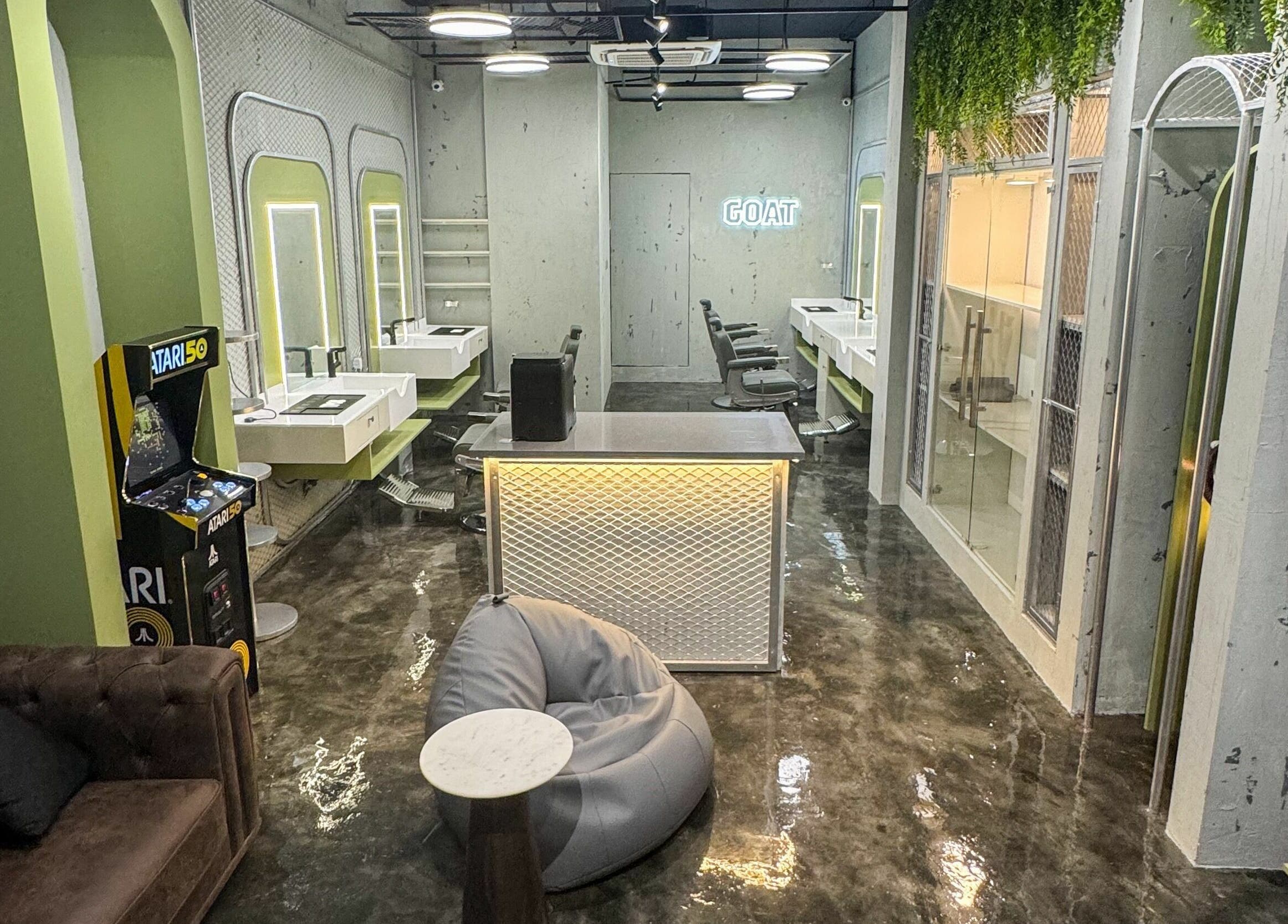 Stylish interior of GOAT Barber in Muscat, OM, featuring modern décor and arcade game.