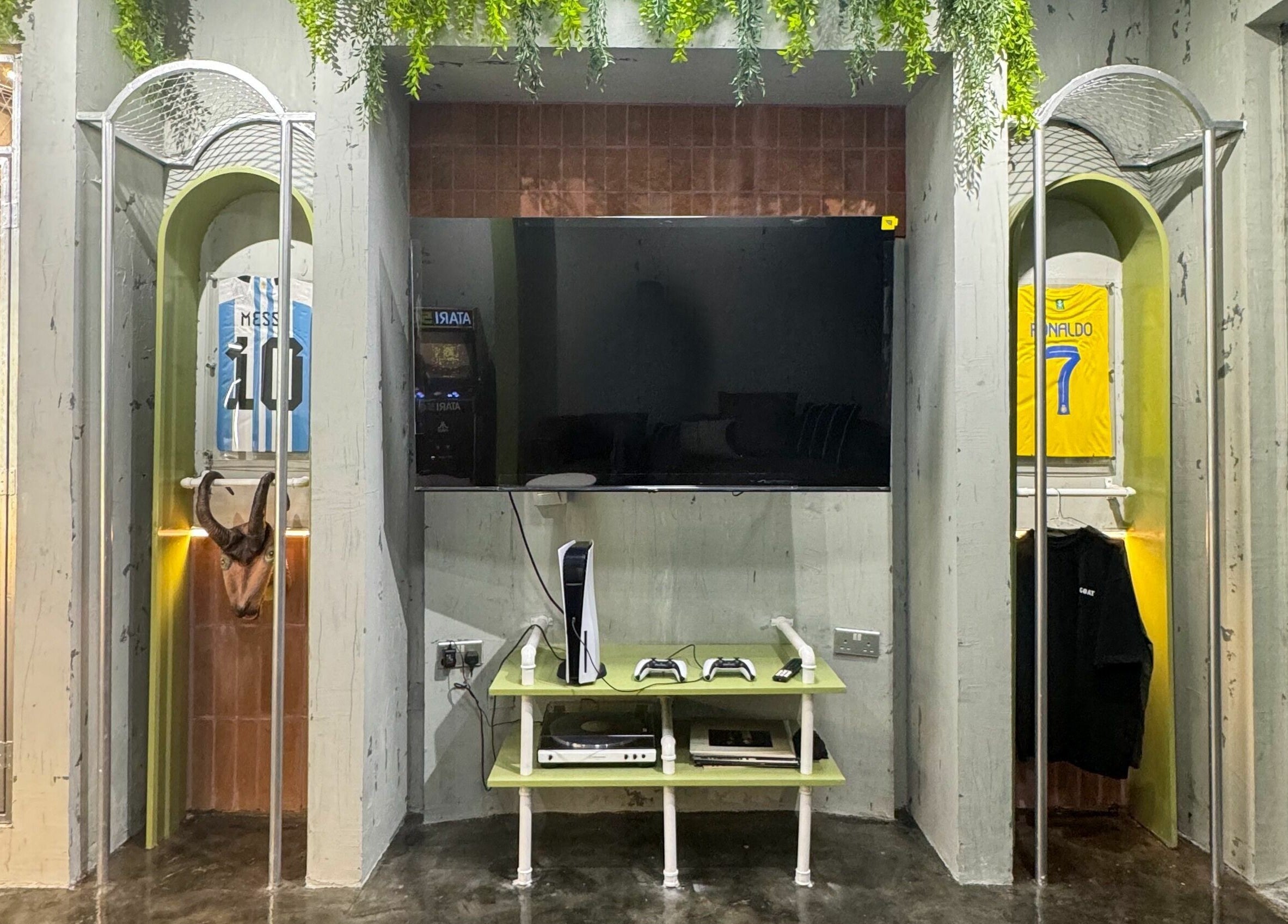 GOAT Barber lounge area with gaming setup and jerseys in Muscat, Muscat Governorate, OM.
