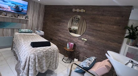 Elegant treatment room at Green Ivy Skin and Spa, Barton Seagrave, England, GB with a cozy massage bed and decor.