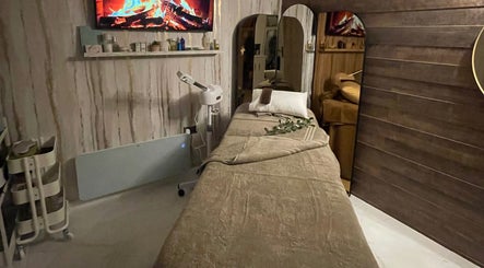 Relaxing treatment room at Green Ivy Skin and Spa, Kettering, England, GB, featuring a massage table and warm decor.