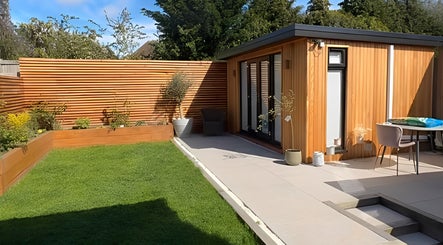 Serene outdoor setup at Green Ivy Skin And Spa, Kettering, England, GB with green lawn and wooden spa building.