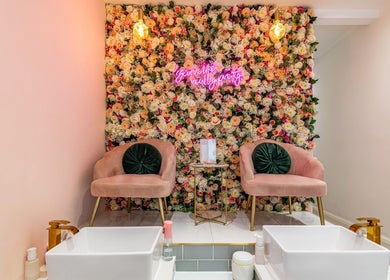 Luxurious floral wall and pink seating at WINK Beauty in London, England, GB offer a relaxing ambiance.