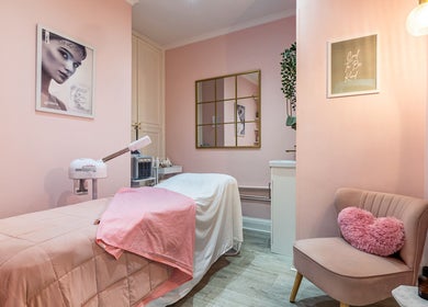 Relaxing treatment room at WINK Beauty in London, England, GB with soft pink hues and cozy decor.