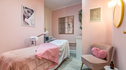 Relaxing treatment room at WINK Beauty in London, England, GB with soft pink hues and cozy decor.