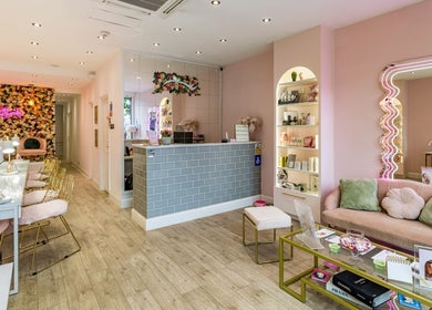 WINK Beauty reception area in London, England, GB with floral decor, modern furnishings, and ambient lighting.