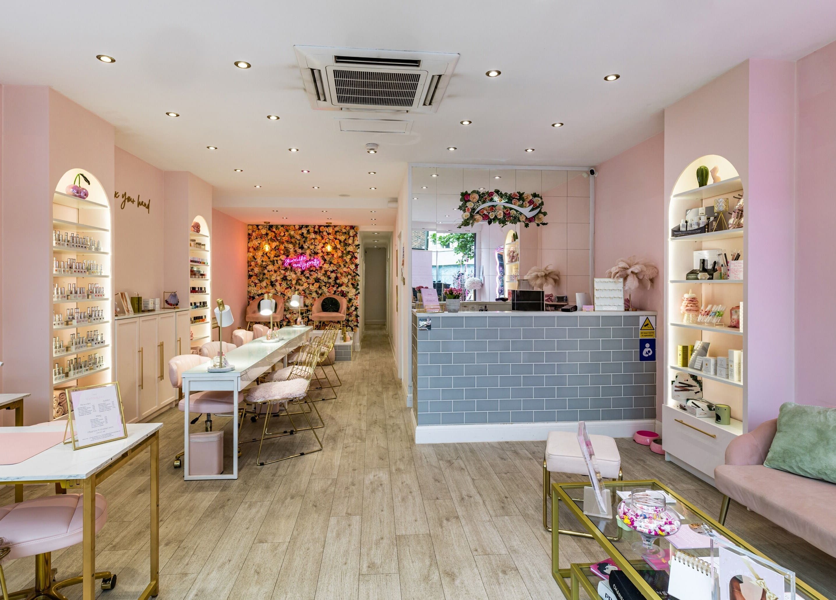 Elegant interior of WINK Beauty - Whetstone in London, featuring chic pink decor and cozy seating.