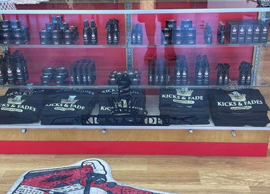 Product display at Kicks And Fades Barbering Co, Idaho Falls, Idaho, US showcasing grooming essentials and branded apparel.