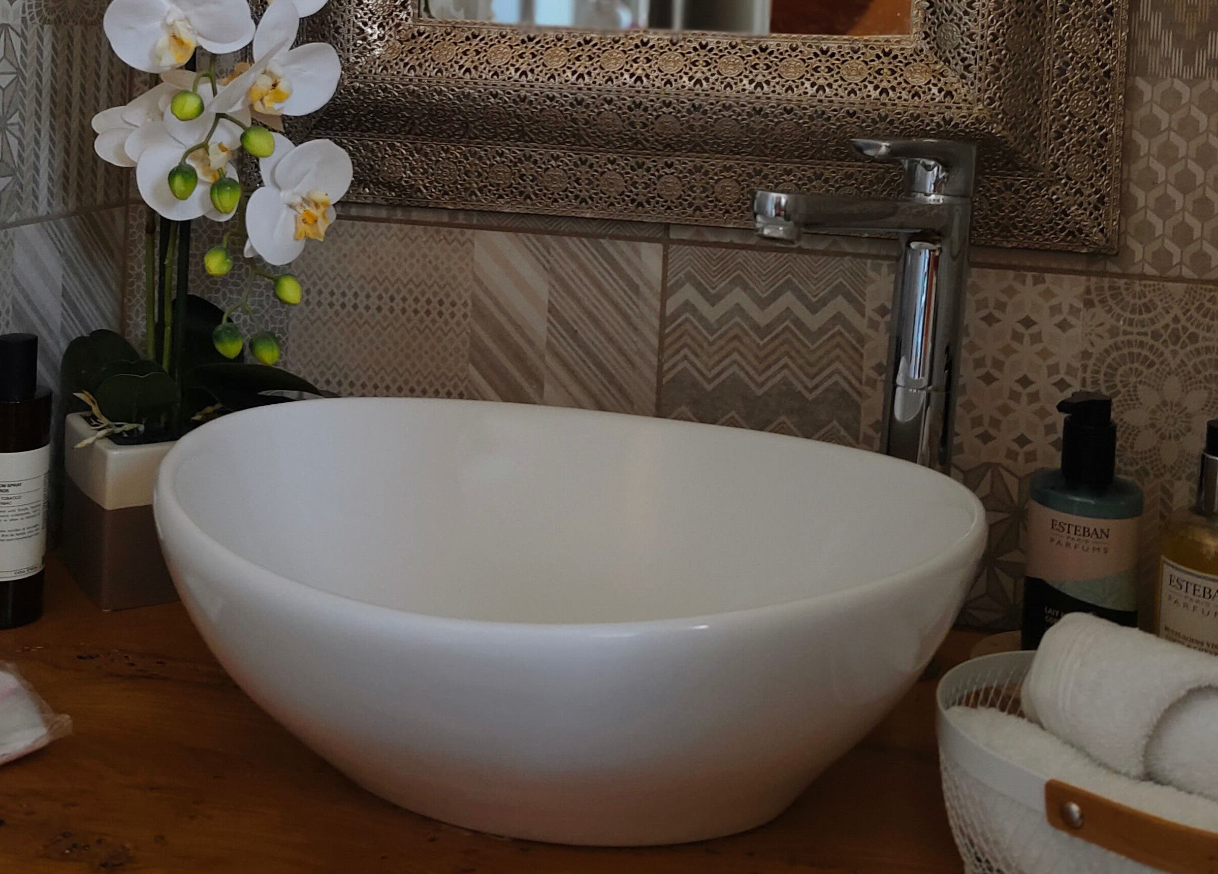 Élégant lavabo chez Kryse Massage, Garéoult, Provence-alpes-côte D'azur, FR, avec orchidée et produits de soin.