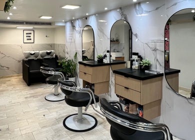 Interior moderno de Colorte Salon Hair & Nails en Carolina, PR con estaciones de belleza elegantes.