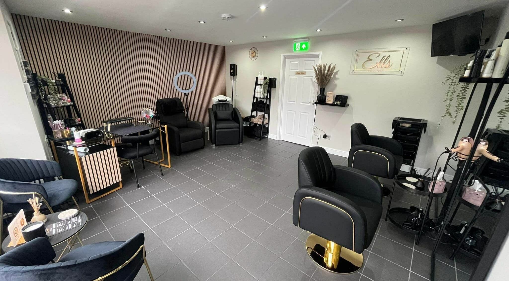 Modern, stylish interior of Ells Hair and Nails, Callington, England, GB, featuring comfortable black chairs.