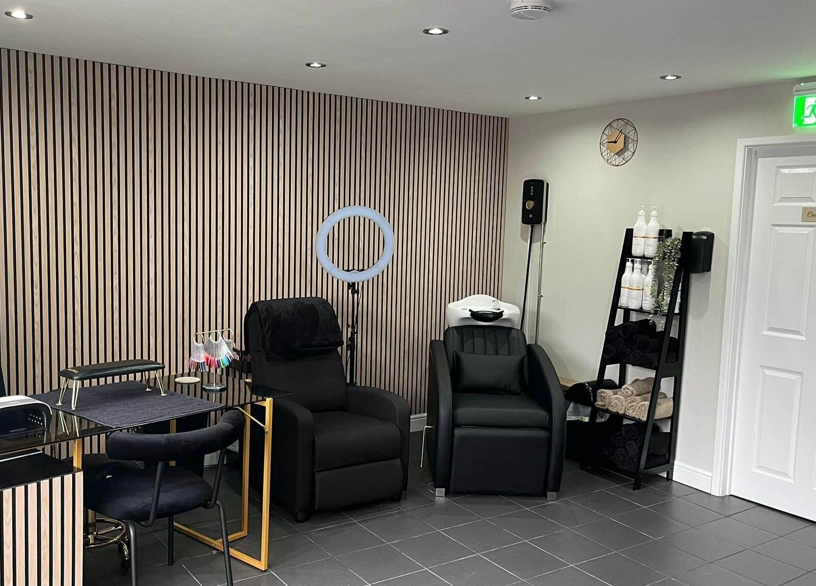 Modern interior at Ells Hair and Nails, Callington, England, GB, showcasing chic styling chairs and nail art supplies.