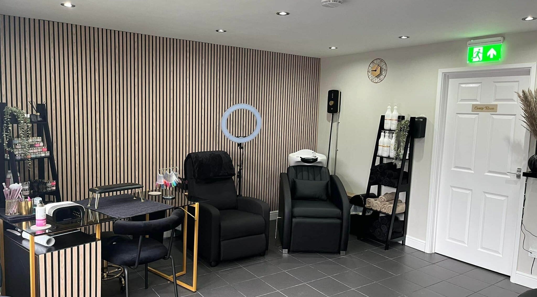 Modern interior at Ells Hair and Nails, Callington, England, GB, showcasing chic styling chairs and nail art supplies.
