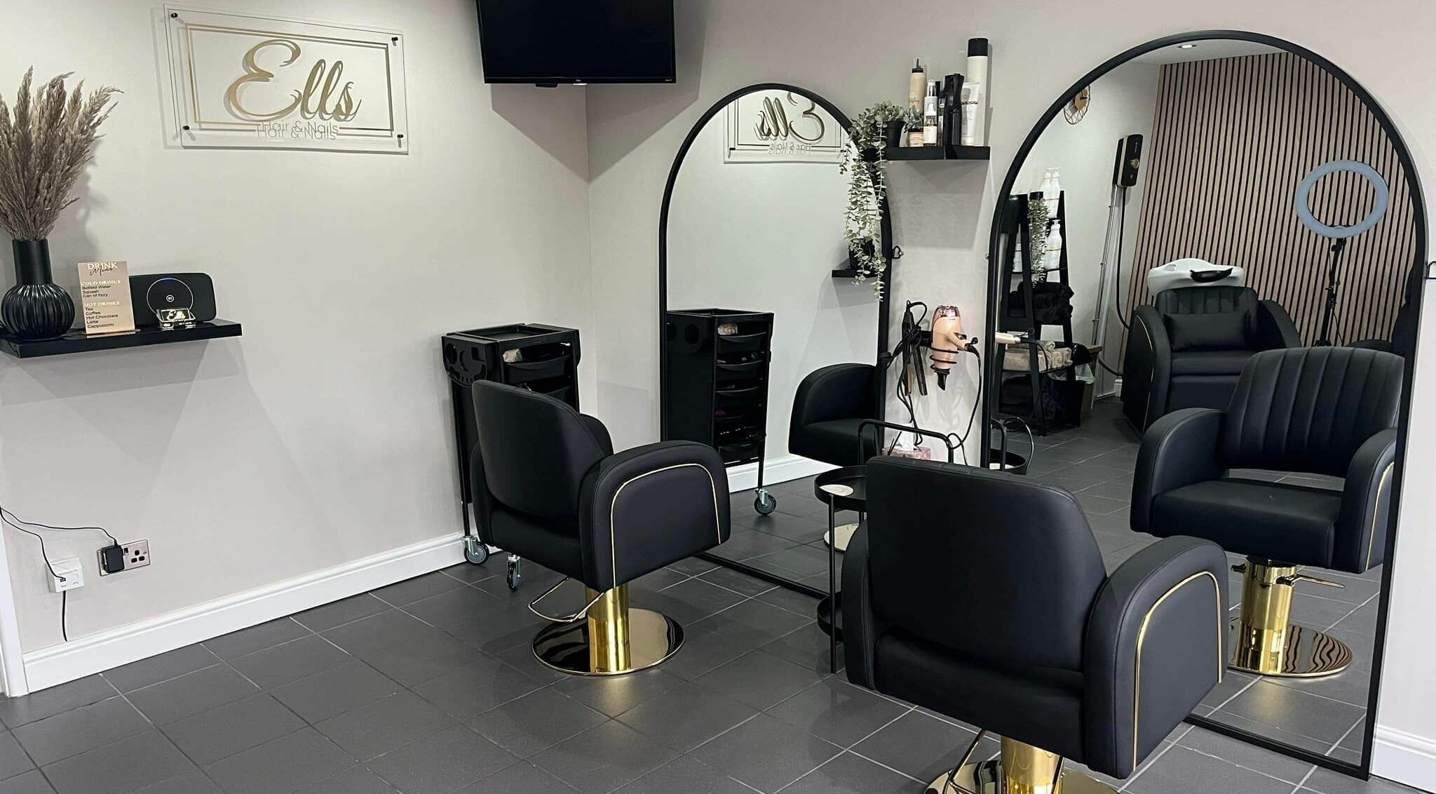 Modern salon interior at Ells Hair and Nails in Callington, England, GB, featuring sleek black chairs and mirrors.