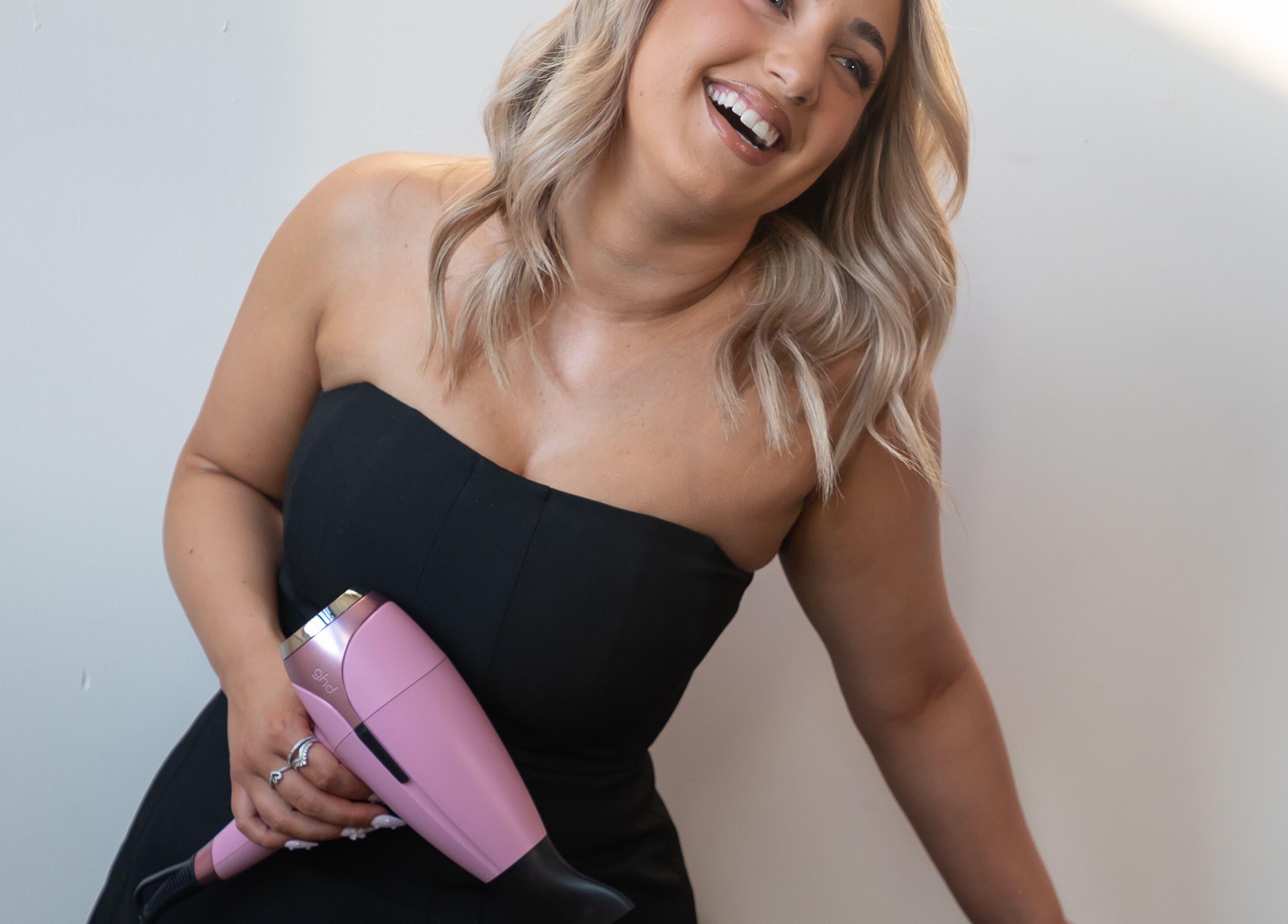 Smiling woman with a hairdryer at StyledByNina, New South Wales, New South Wales, AU.