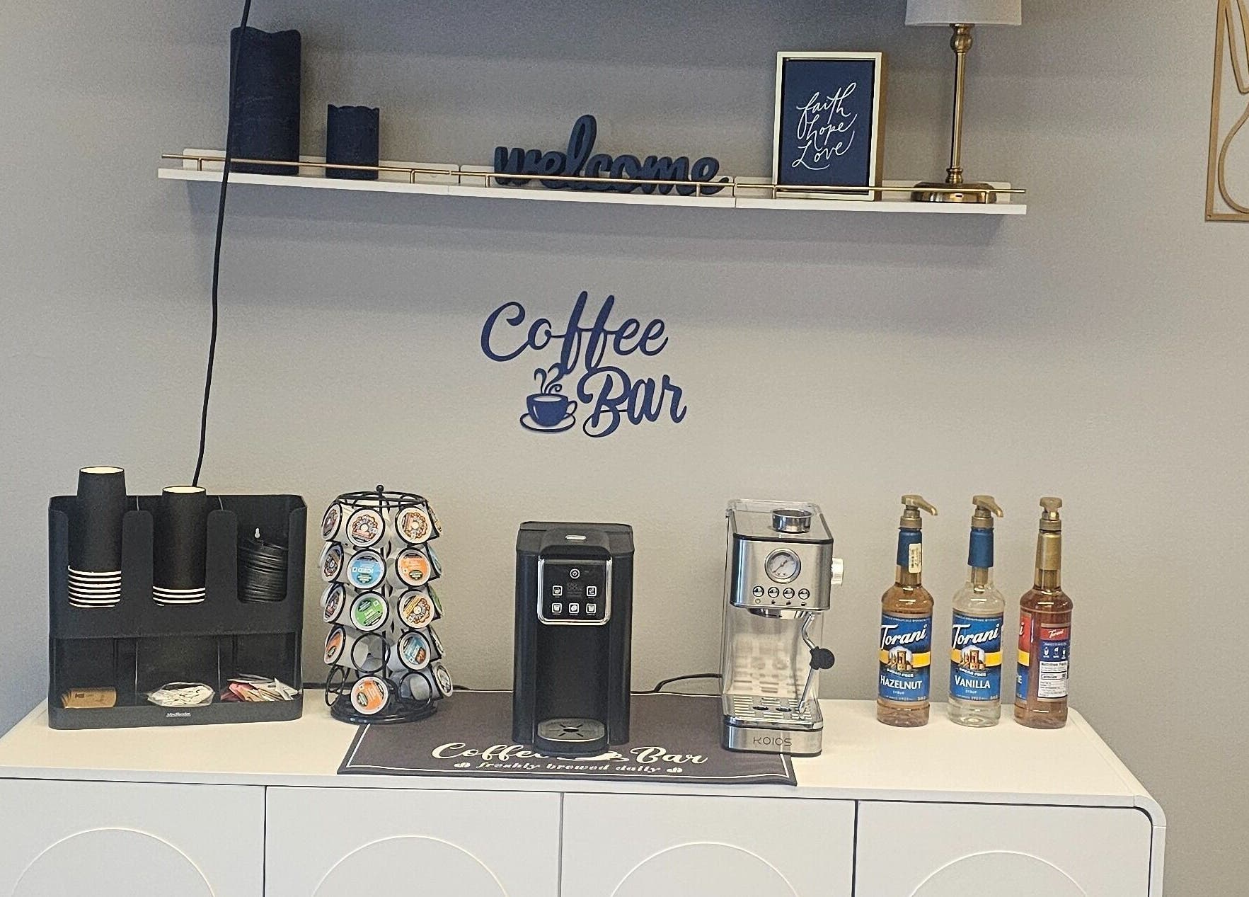 Coffee bar setup at Chizeled Contours Body Aesthetics, Twinsburg, Ohio, US, featuring a coffee maker and syrups.