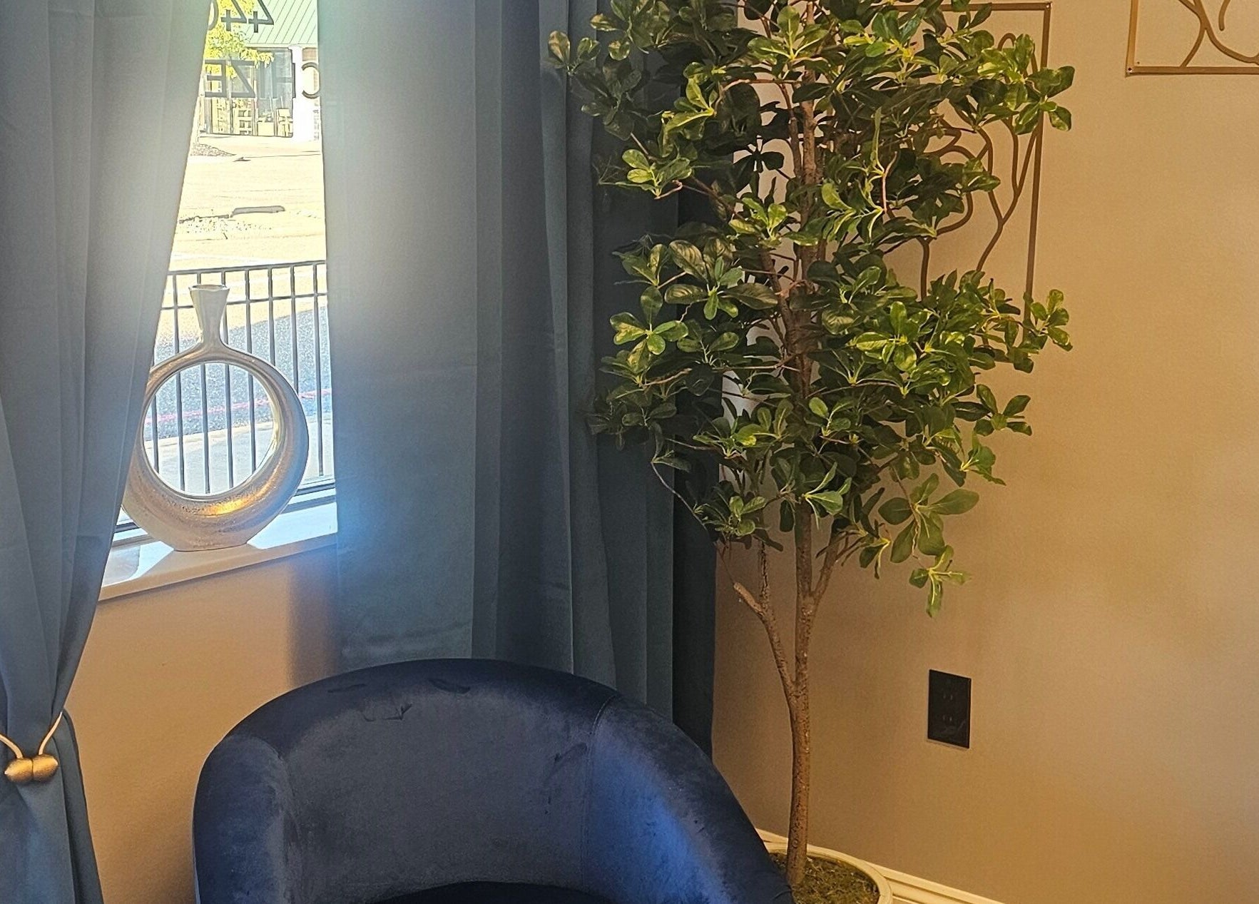 Tranquil corner with blue chair and plant at Chizeled Contours Body Aesthetics in Twinsburg, Ohio, US.