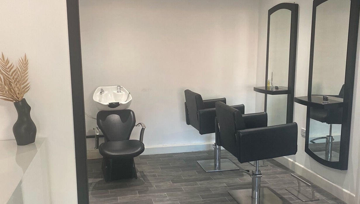 Modern salon interior at More Than Aesthetics, Parkgate, England, GB with sleek black styling chairs and mirrors.