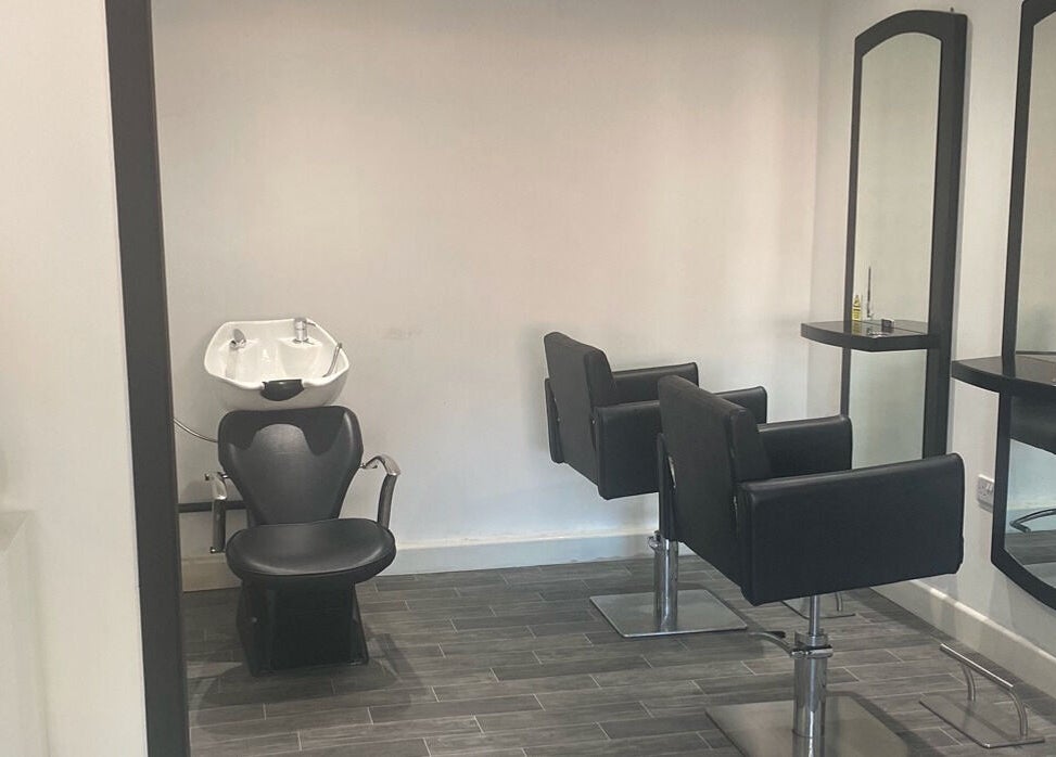 Modern salon interior at More Than Aesthetics, Parkgate, England, GB with sleek black styling chairs and mirrors.