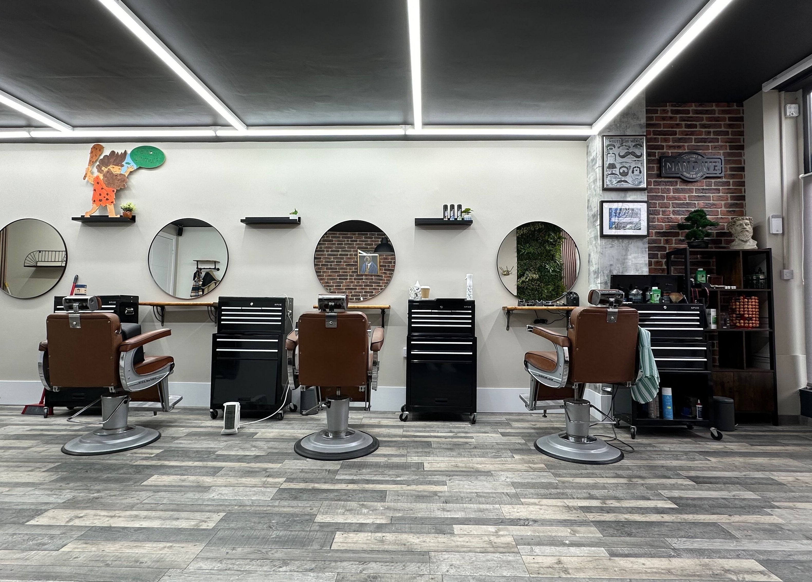 Modern interior of The Man Cave Barbershop, Northampton, England, GB with sleek barber chairs and mirrors.