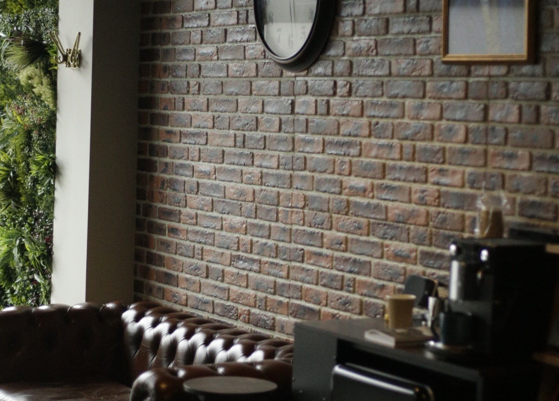 Cozy, stylish leather seating at The Man Cave Barbershop, Northampton, England, GB, with a rustic brick interior.