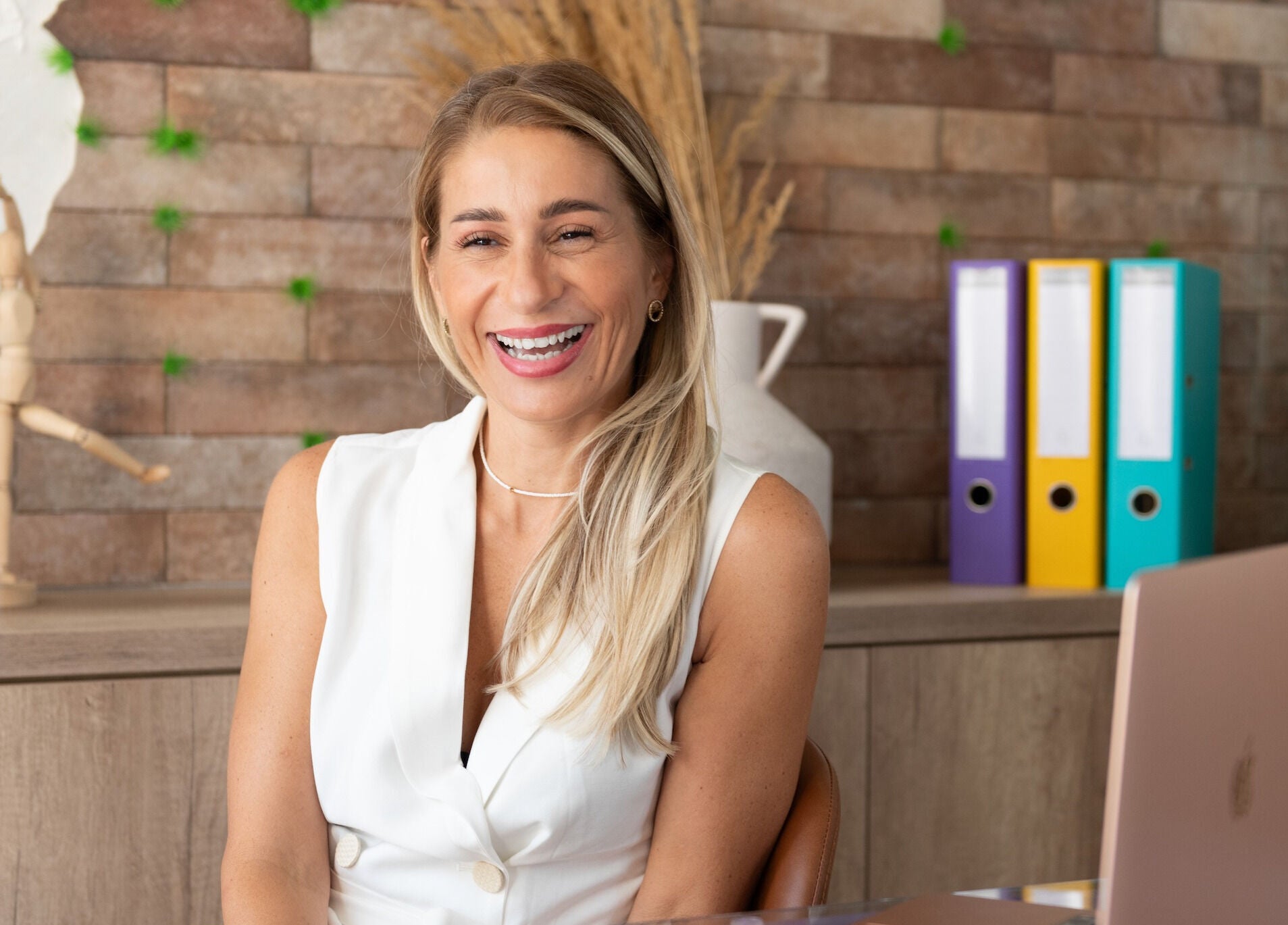 Žena u bijeloj majici smiješi se u Simplicity Beauty Centeru, Podgorica, ME.