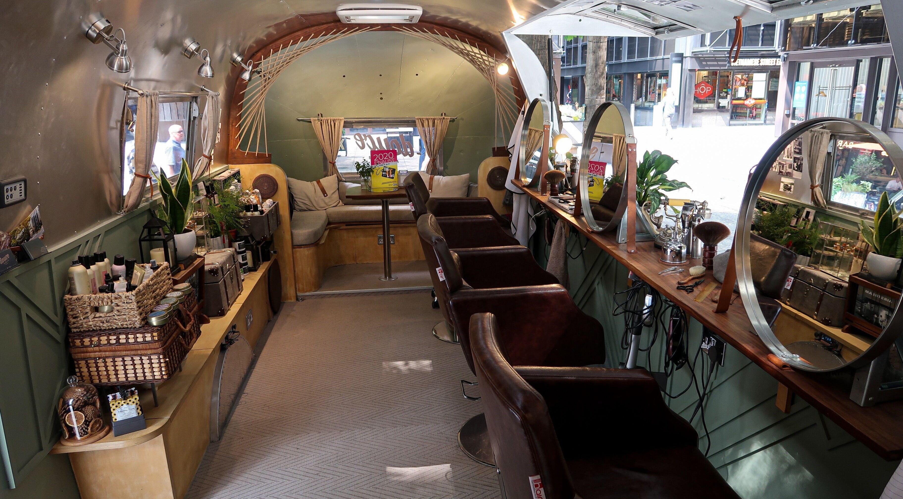 Interior of Douce Shoreditch mobile salon in an Airstream, featuring mirrors and styling chairs in London, England, GB.