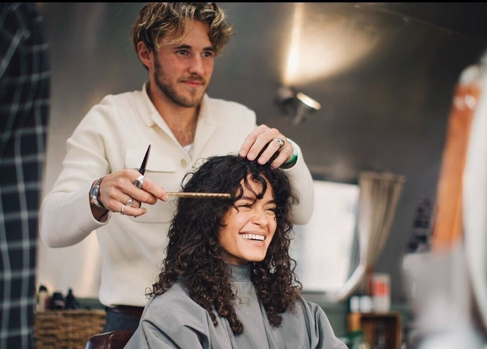 Hair stylist crafting curly look at Douce Shoreditch, London, England, GB salon.