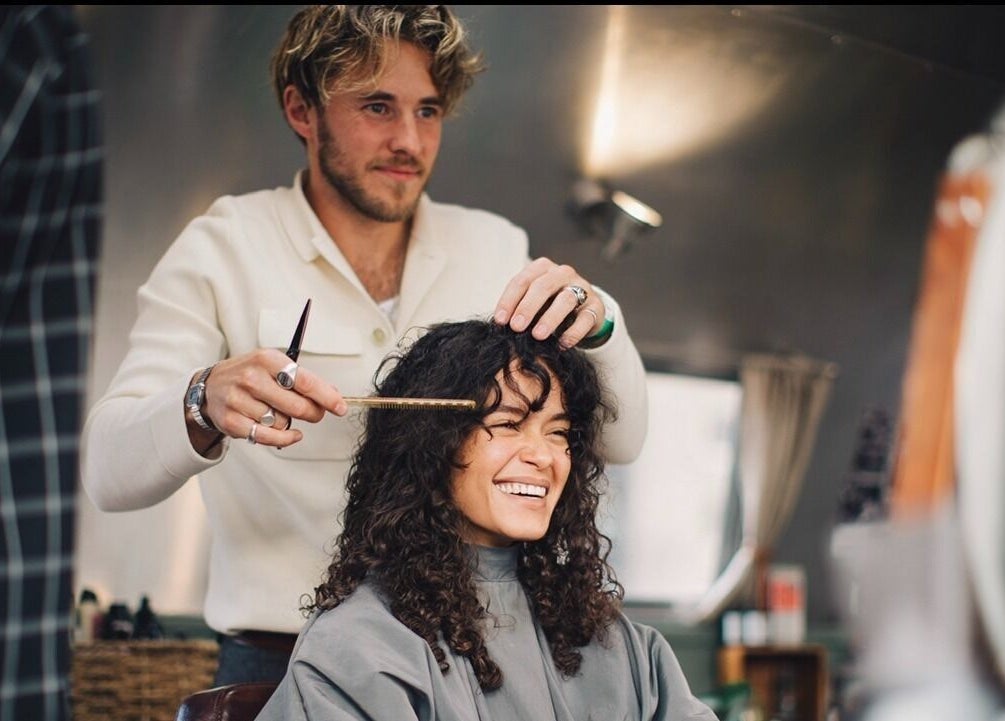 Hair stylist crafting curly look at Douce Shoreditch, London, England, GB salon.
