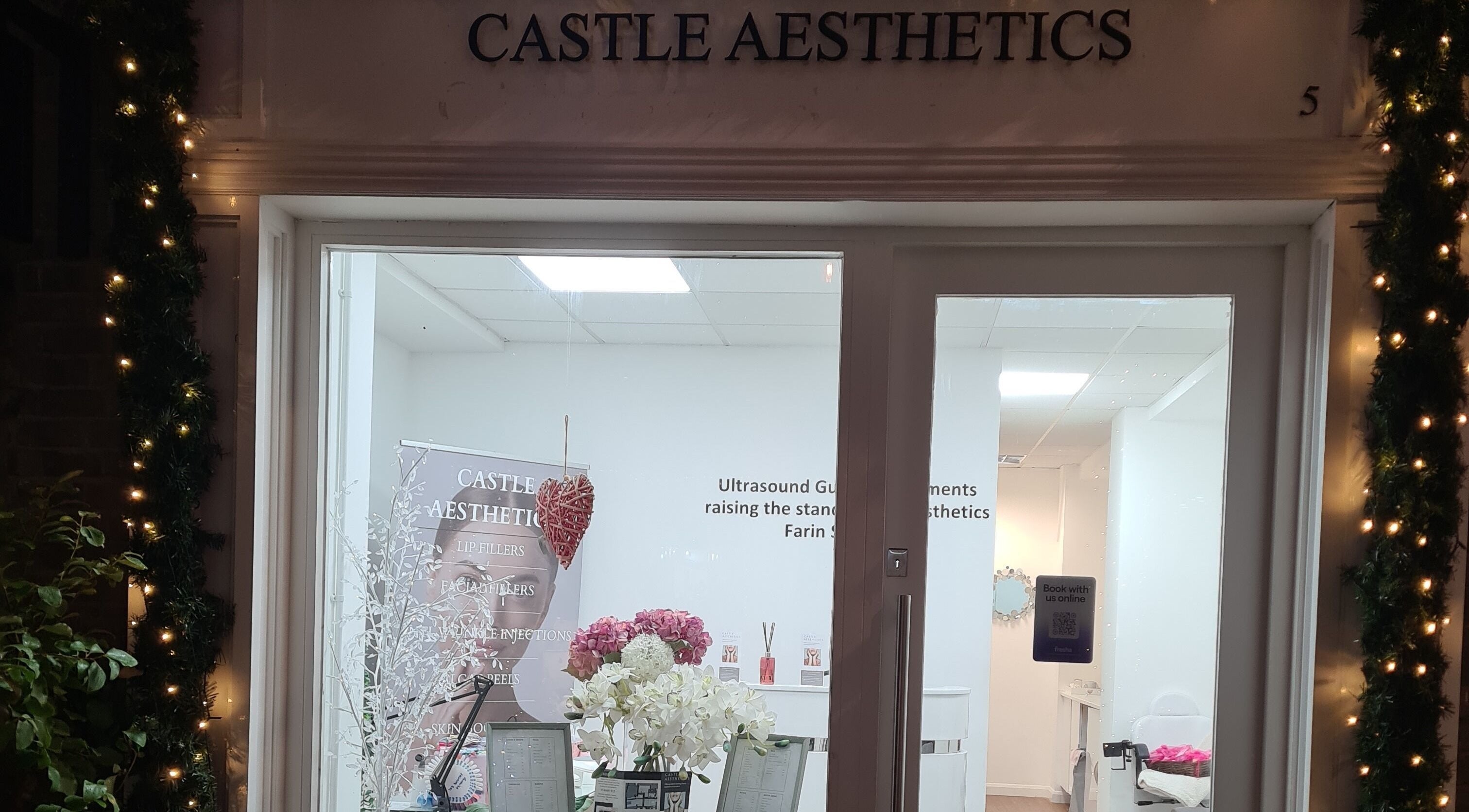 Charming entrance of Avc beauty Castle Aesthetics in Colchester, England, GB, adorned with festive lights.