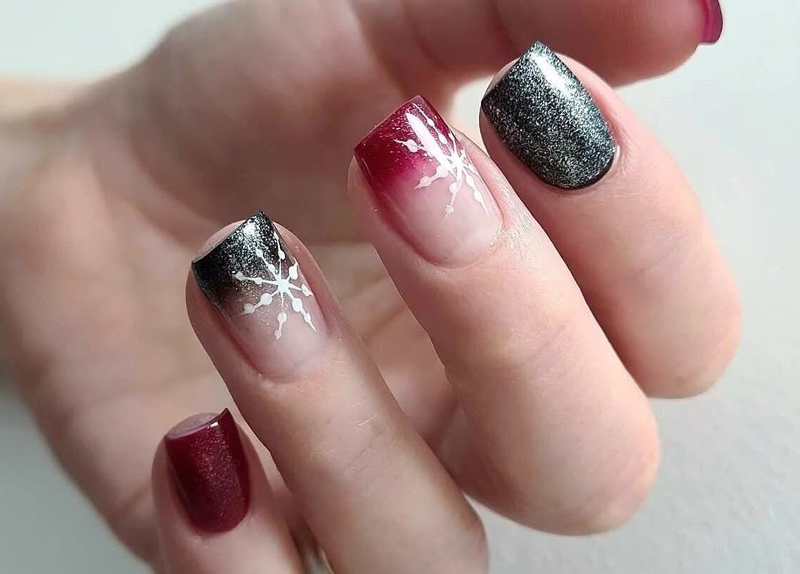 Chic red and black nail art with snowflake design at Avc Beauty Castle Aesthetics, Colchester, England, GB.