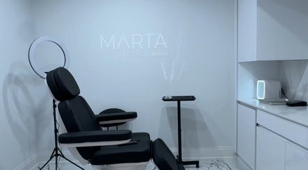 Modern treatment room at Aesthetic Nurse Marta in Vaughan, Ontario, CA with sleek black chair and ring light.