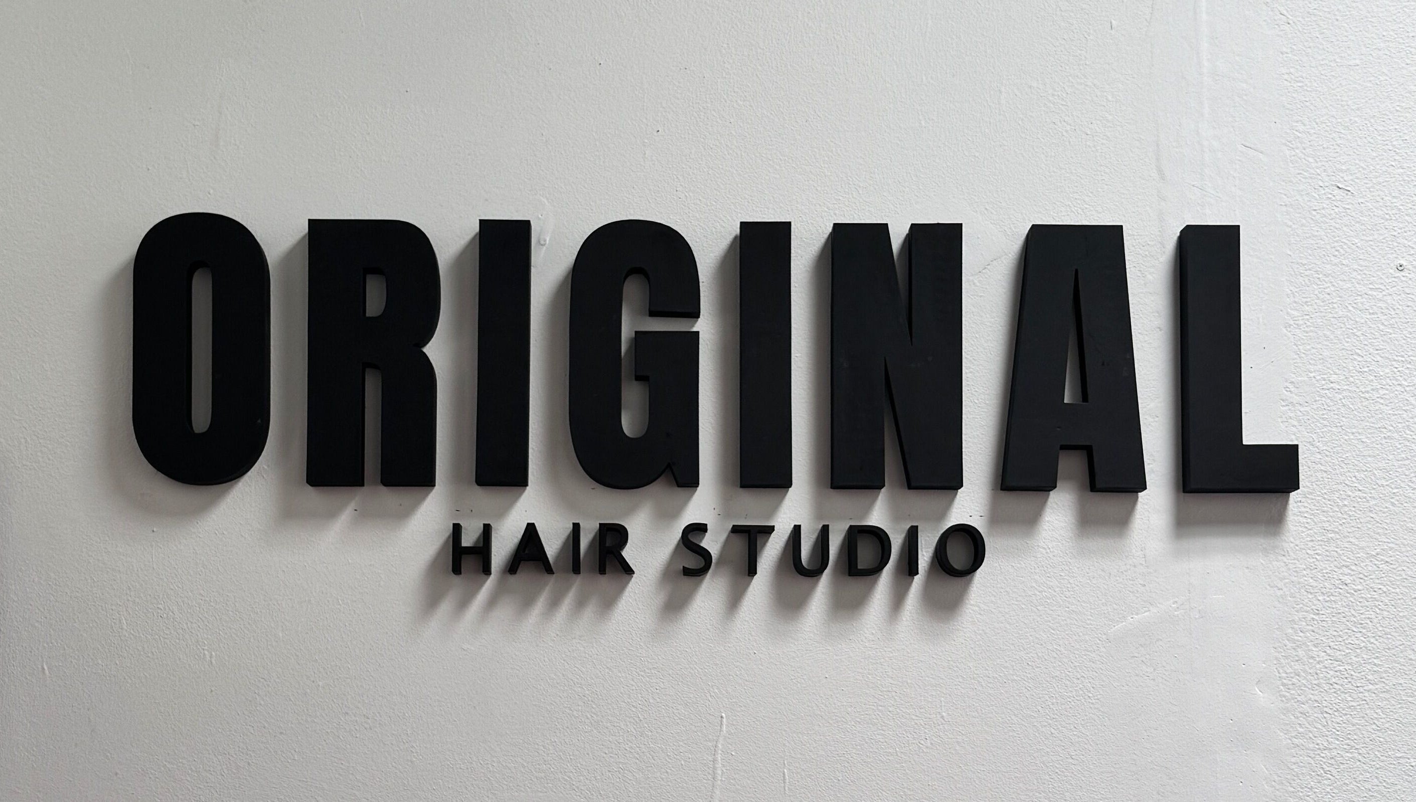 Letrero de Original Hair Studio en Antigua Guatemala, Sacatepéquez, GT, con letras negras.