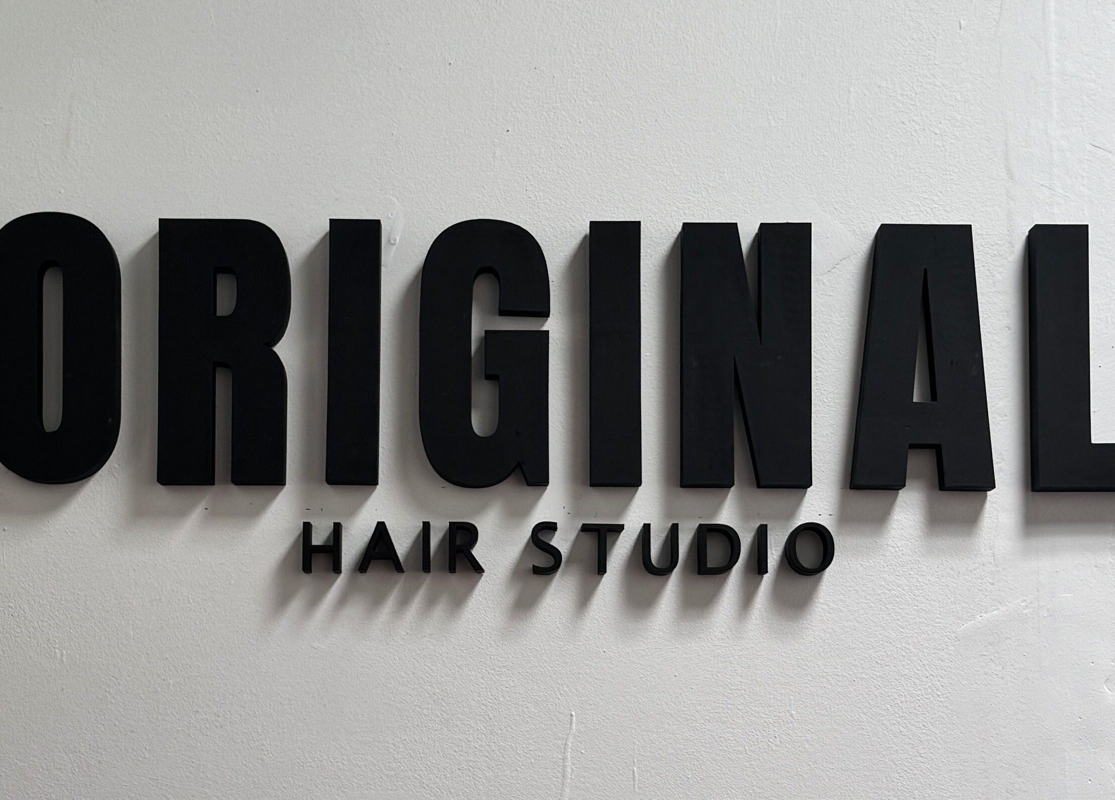 Letrero de Original Hair Studio en Antigua Guatemala, Sacatepéquez, GT, con letras negras.