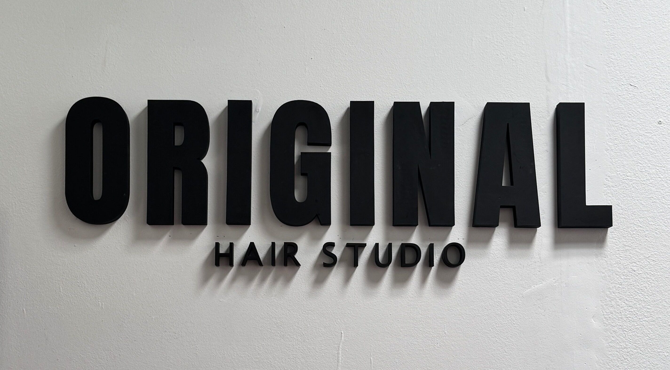 Letrero de Original Hair Studio en Antigua Guatemala, Sacatepéquez, GT, con letras negras.