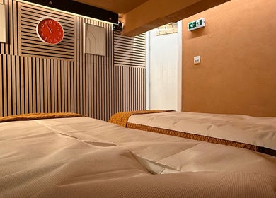 Relaxing treatment room at OPULENCE THAI SPA | Covent Garden in London, England, GB with warm decor and twin beds.