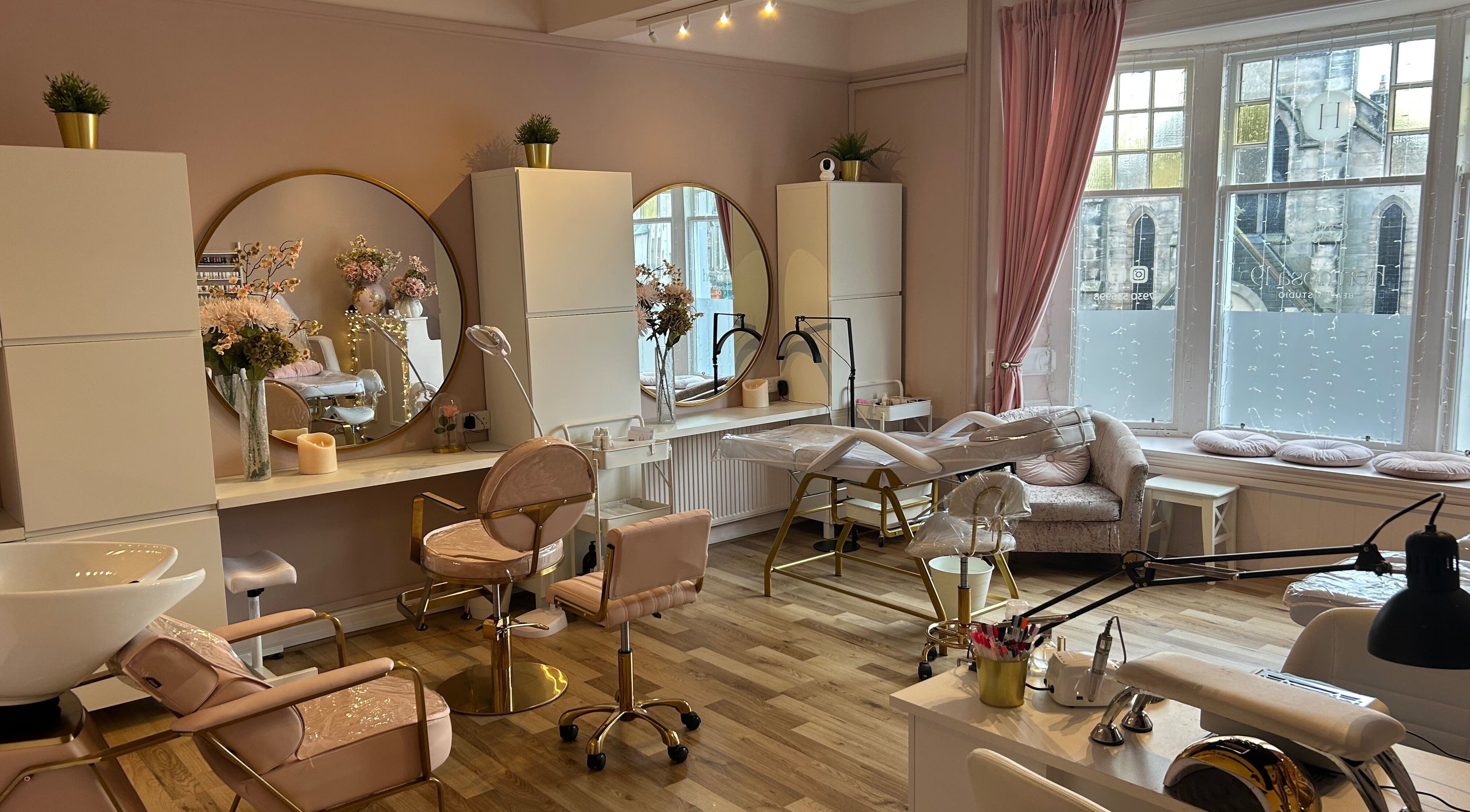 Chic interior of Hermosa19 Beauty in Peebles, Scotland, GB showcasing plush seating and large mirrors.