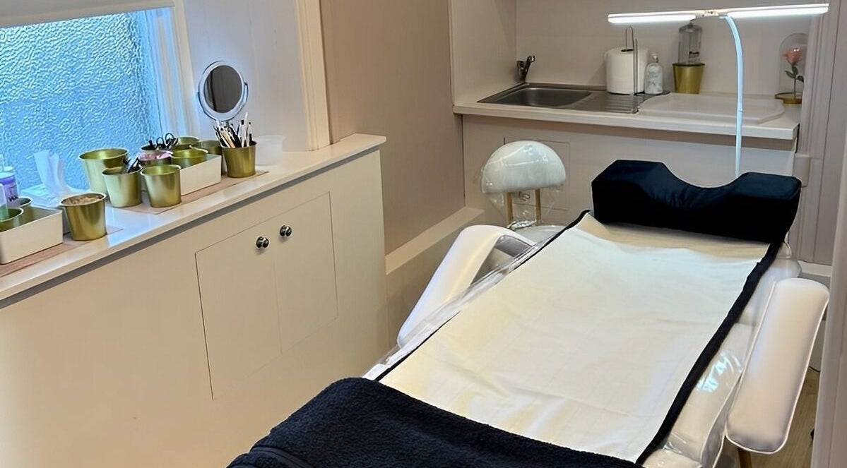 Calm treatment room at Hermosa19 Beauty, Peebles, Scotland, GB with white and gold decor.
