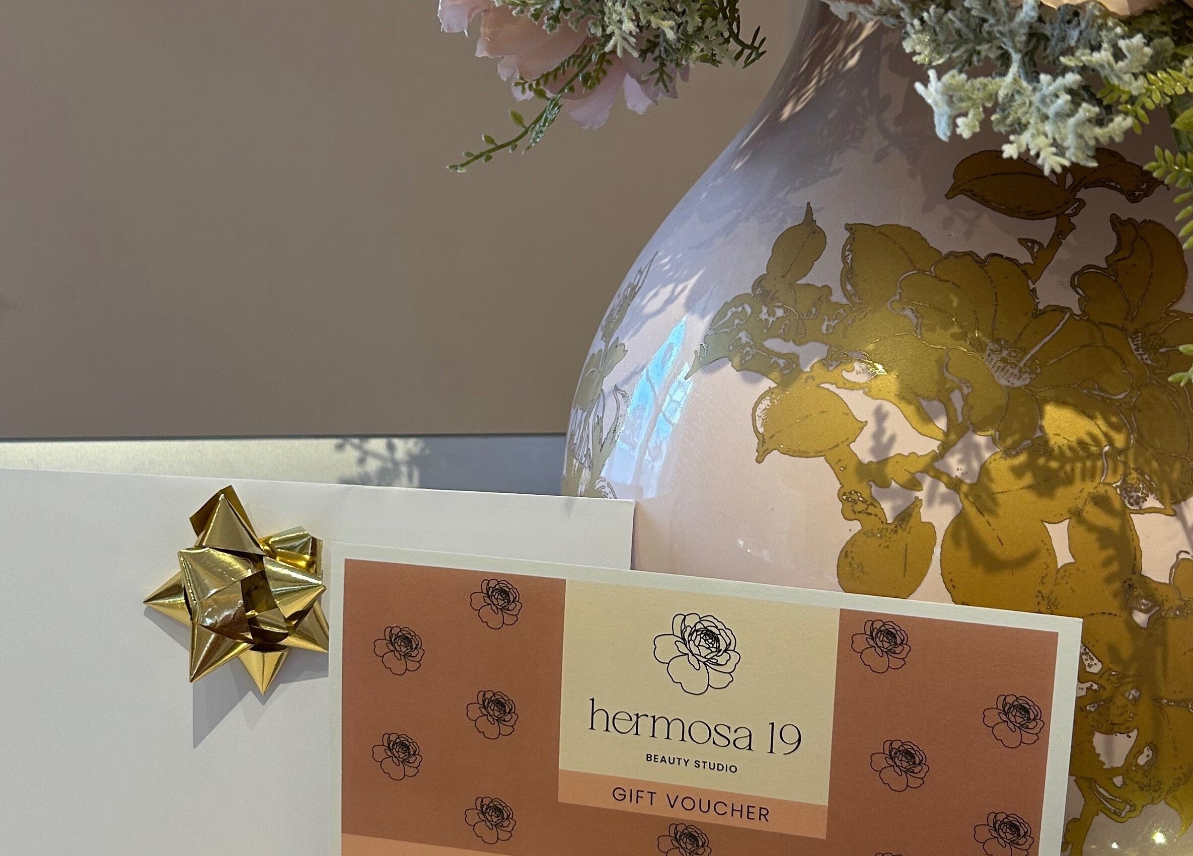 Hermosa19 Beauty gift voucher displayed beside floral vase at Peebles, Scotland, GB.